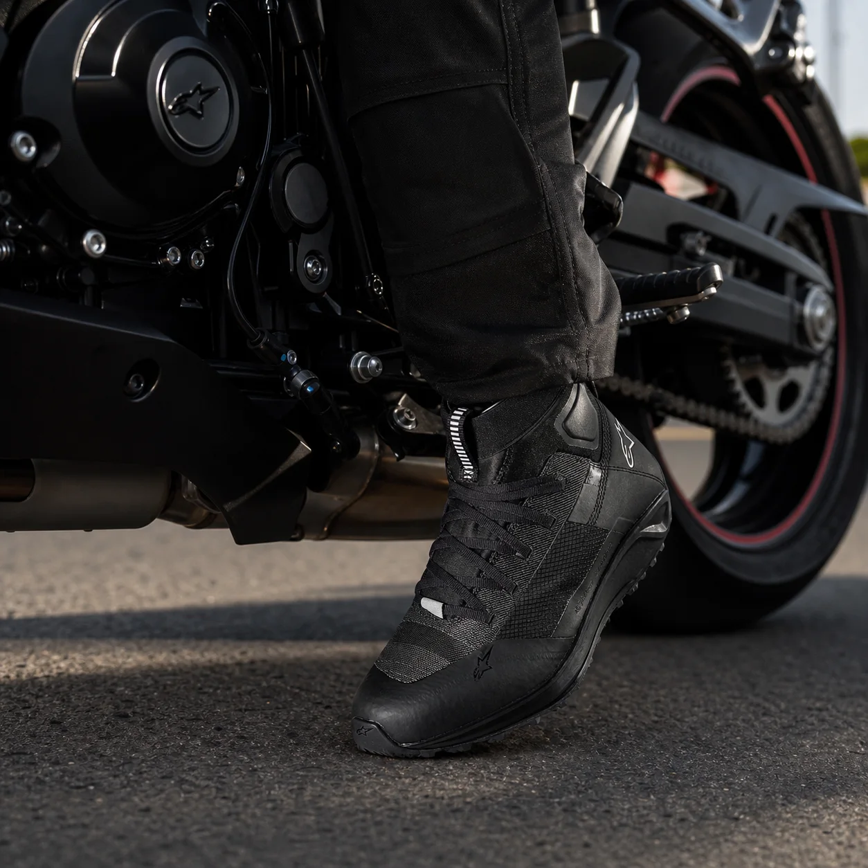 Calzado Alpinestars usado junto al pedalín de una motocicleta